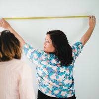 Lucie en train de mesurer un mur avec une cliente